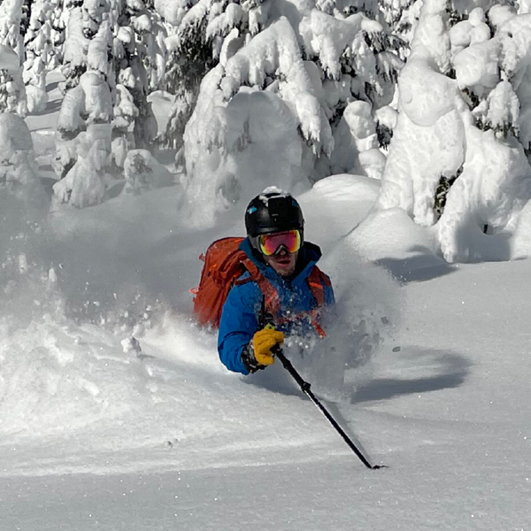 man skiing through powder snow