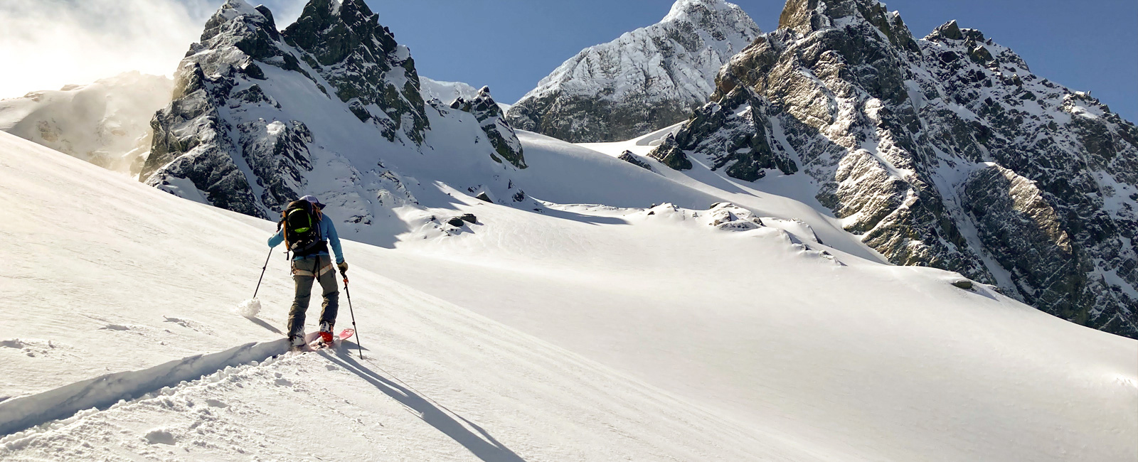 man ski traversing across snowy slope